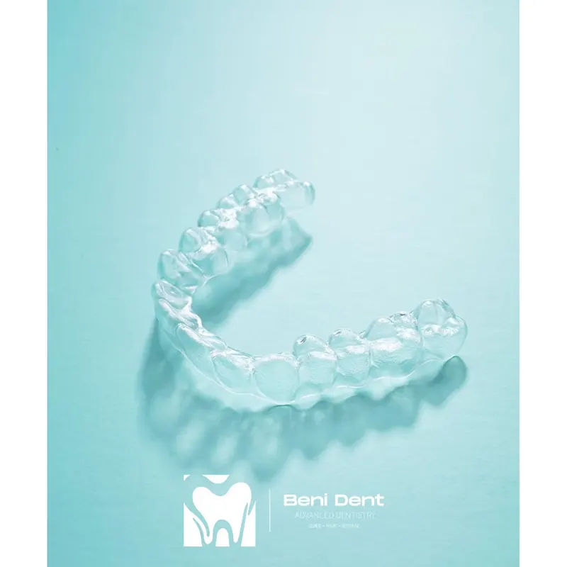A clear aligner on a light turquoise background